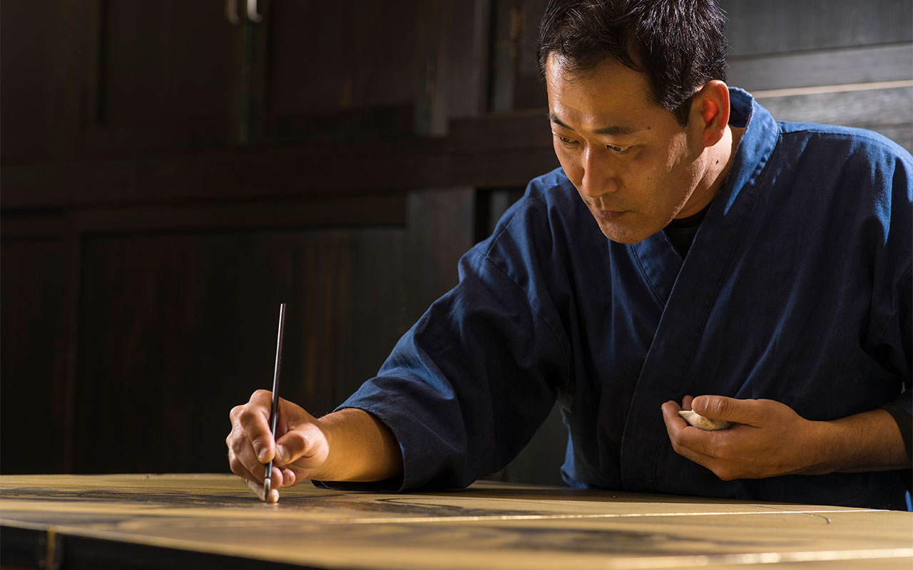 職人が屏風を描く様子
